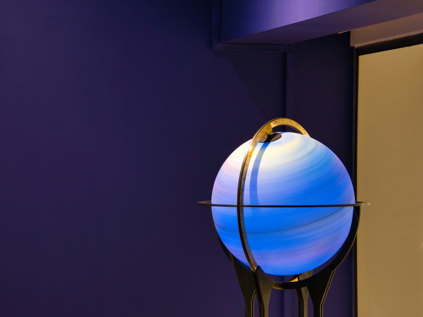 Un globo celeste luminoso su un supporto metallico.