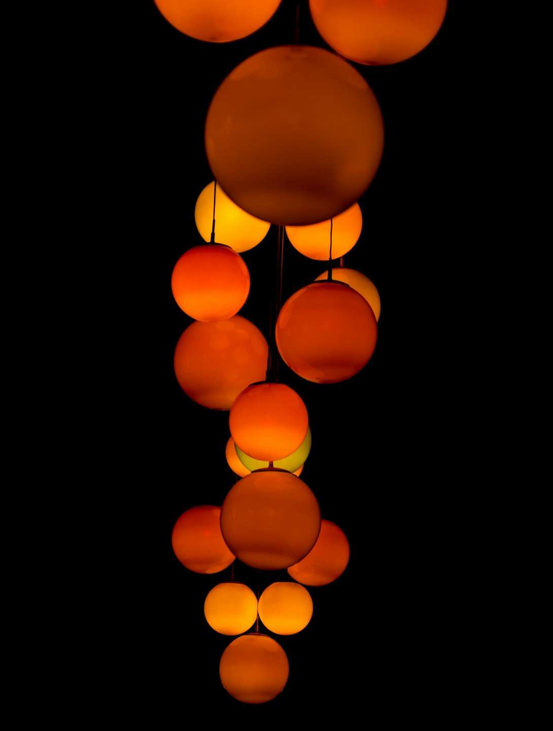 Sfere luminose arancioni e gialle fluttuano verticalmente.